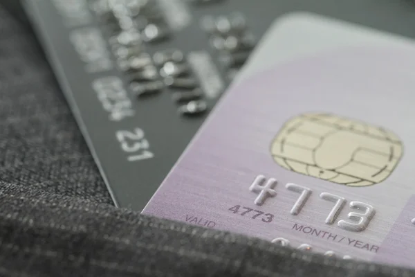 Kreditkort i mycket grunt fokus med grå kostym bakgrund som — Stockfoto