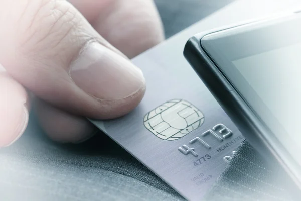 Kreditkort i mycket grunt fokus med grå kostym bakgrund som — Stockfoto