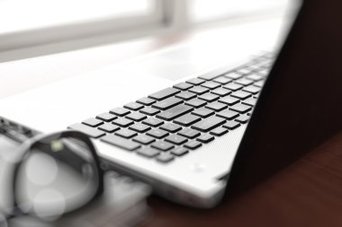 Ofis işyeri dizüstü bilgisayar ve ahşap masa üstünde smartphone