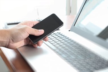 Dizüstü bilgisayar ve cep telefonu kullanma office iş adamı el