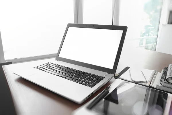 Posto di lavoro ufficio con laptop e smartphone su tavolo in legno — Foto Stock