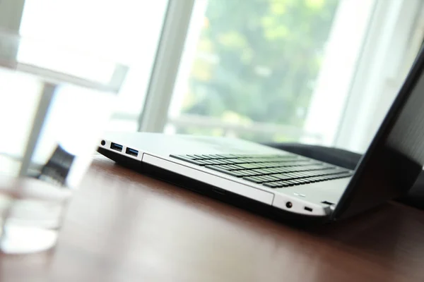 Oficina de trabajo con portátil y smartphone en mesa de madera — Foto de Stock