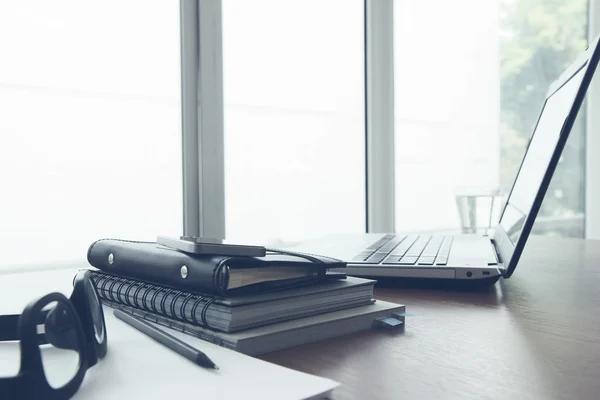 Posto di lavoro ufficio con laptop e smartphone su tavolo in legno — Foto Stock