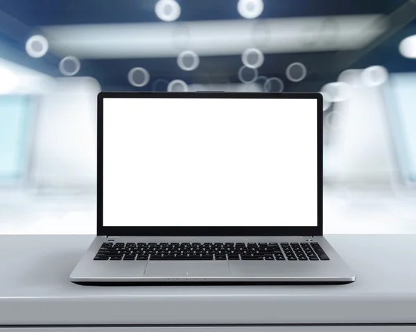 Laptop with blank screen on white desk with blurred background a — Stock Photo, Image