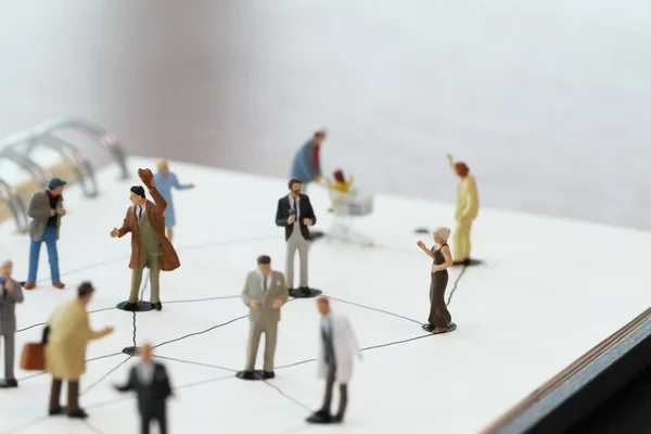 Close up of miniature people with social network diagram on open — Stock Photo, Image