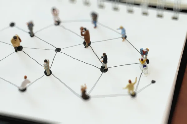 Gros plan des personnes miniatures avec diagramme de réseau social sur open — Photo