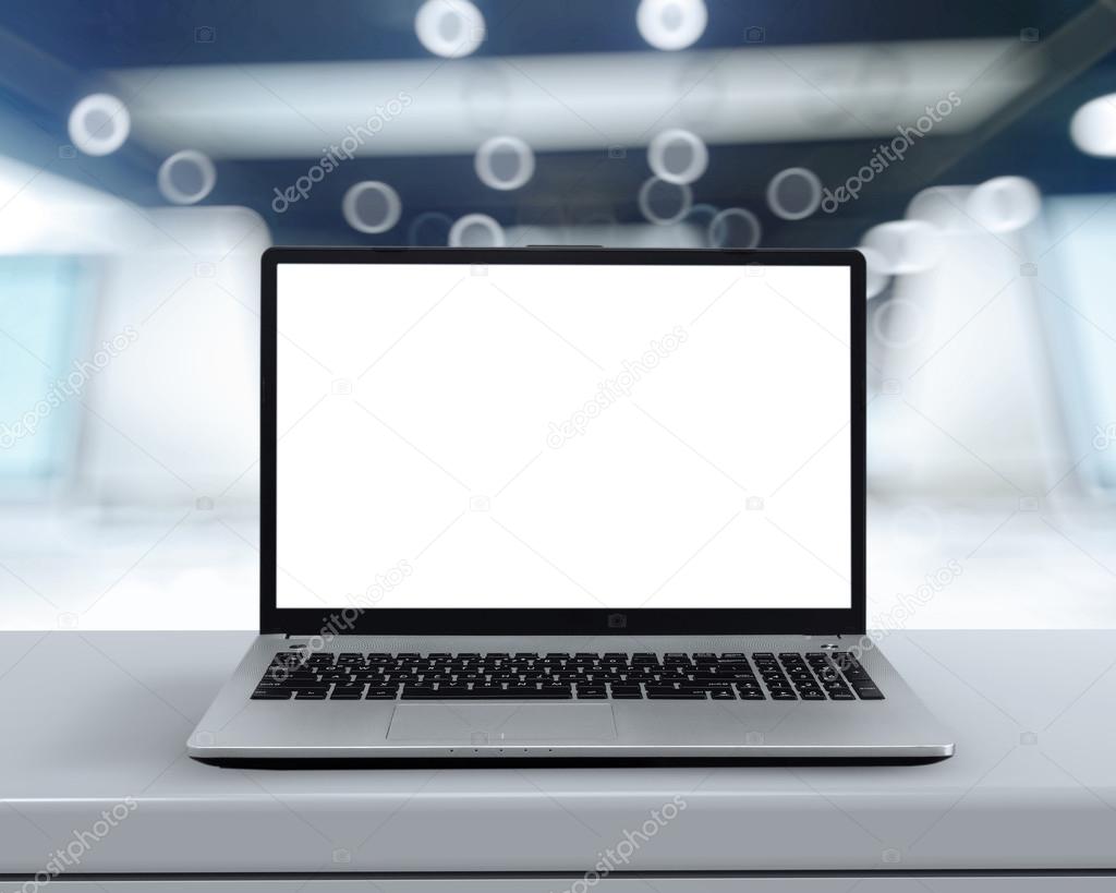 Laptop with blank screen on white desk with blurred background a