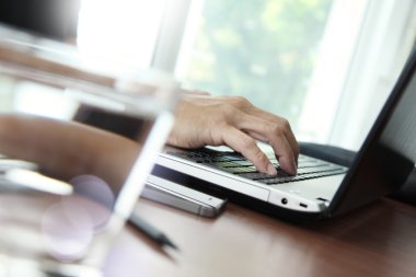 İş adamı el ahşap dizüstü bilgisayar üzerinde çalışan yakın çekim