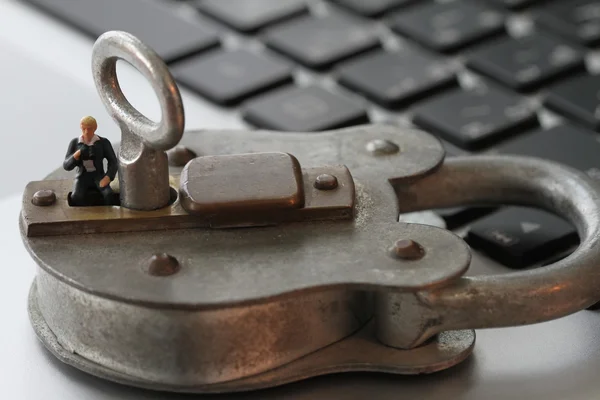 Internet security concept-miniature businessman stand on old key — Stock Photo, Image