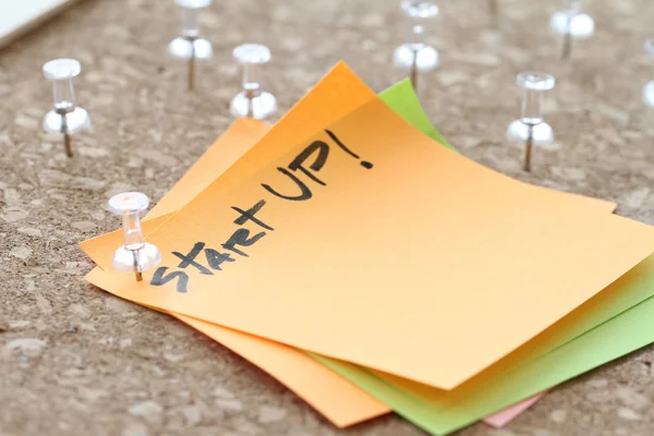 Close up on pin and start up word on sticky note with cork board — Stock Photo, Image