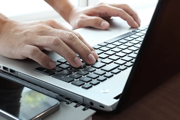 Закрытие руки бизнесмена, работающего на ноутбуке на woo — стоковое фото