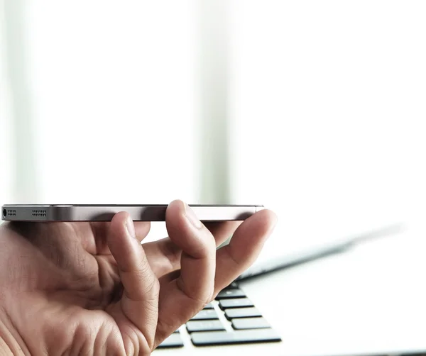 Empresário mão usando laptop e telefone celular no escritório — Fotografia de Stock