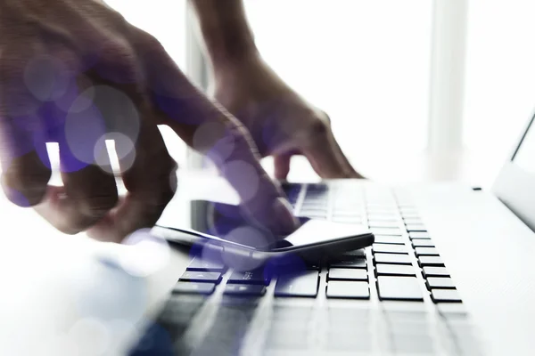 Businessman hand using laptop and mobile phone  on wooden desk a — Stock Photo, Image