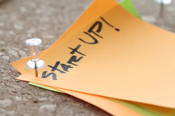 Close up on pin and start up word on sticky note with cork board — Stock Photo, Image