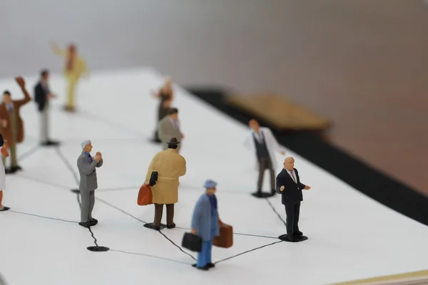 Close-up van miniatuurmensen met sociaal netwerkdiagram op open — Stockfoto