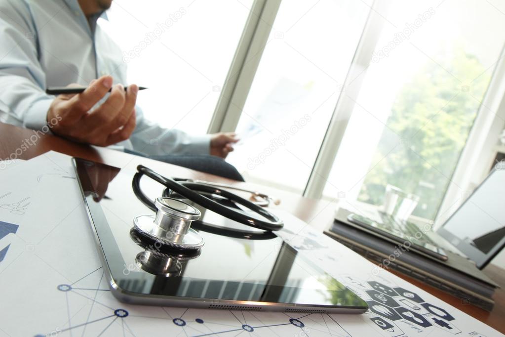 Doctor working with digital tablet and laptop computer in medica