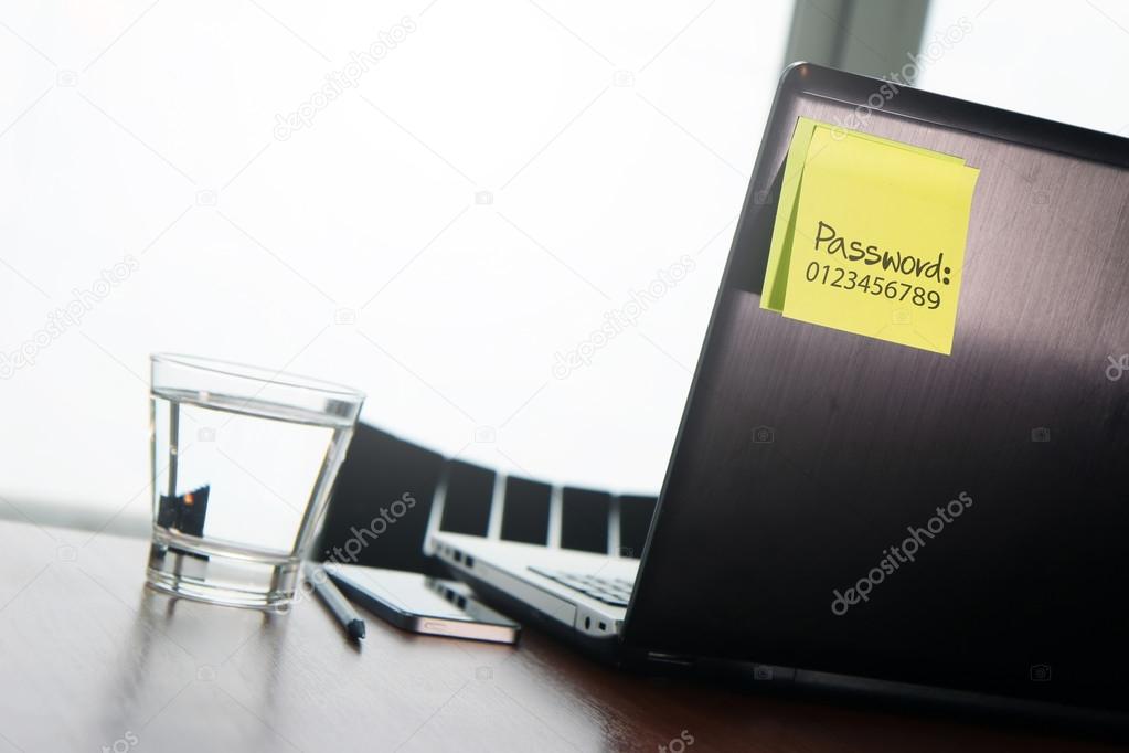 easy password on sticky note on back Laptop in office room as co