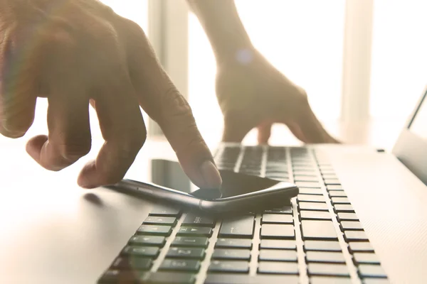 Designer hand working and smart phone and laptop on wooden desk — Stock Photo, Image