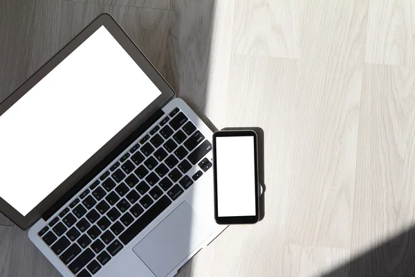 Pusty ekran laptopa z inteligentnych telefonów jest na drewniane biurko — Zdjęcie stockowe
