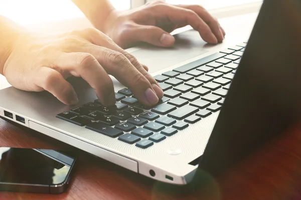 Close up of business man hand working on laptop computer on wood — Stock Photo, Image