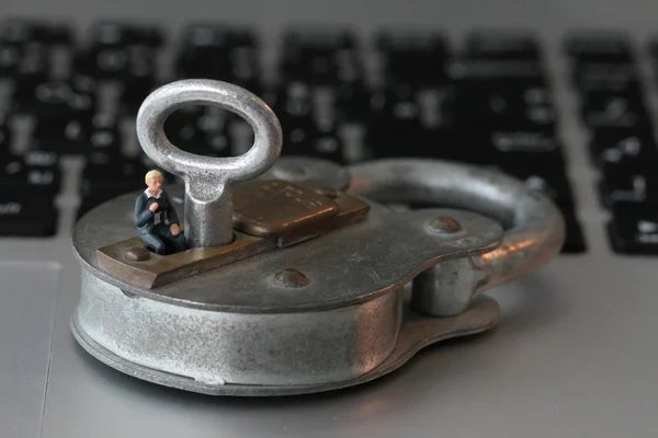 Internet conceito de segurança em miniatura empresário stand on old key — Fotografia de Stock