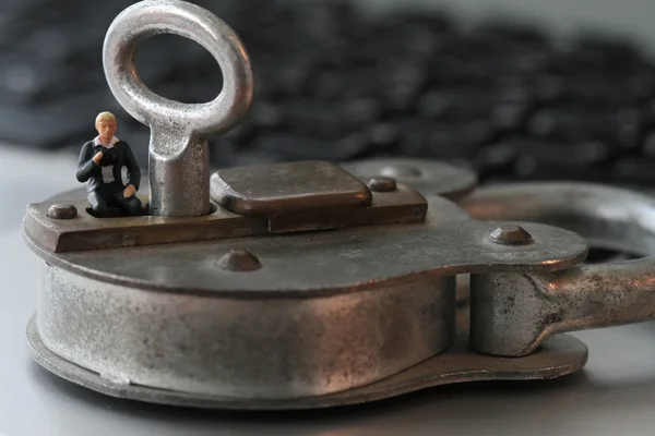 Internet security concept-miniature businessman stand on old key — Stock Photo, Image