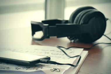 Closeup jack kulaklık üzerinde nota pape ile akıllı telefon