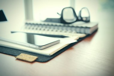 Smartphone close-up,  planning book on wooden desk work space co