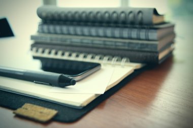 Smartphone close-up,  planning book on wooden desk work space co