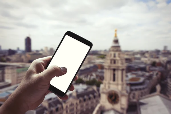 Man hand holding blank screen smartphone against london city blu — 图库照片