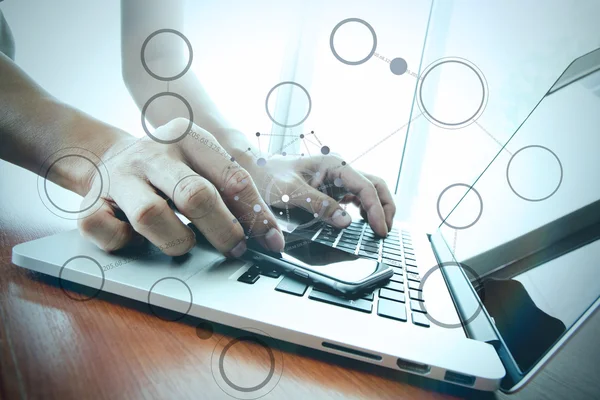 Hombre de negocios mano trabajando con el teléfono inteligente con el ordenador portátil — Foto de Stock