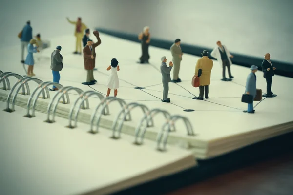 Gros plan des personnes miniatures avec diagramme de réseau social sur open — Photo