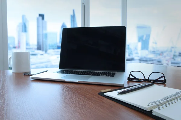 Lieu de travail de bureau avec ordinateur portable à écran vierge et téléphone intelligent sur woo — Photo