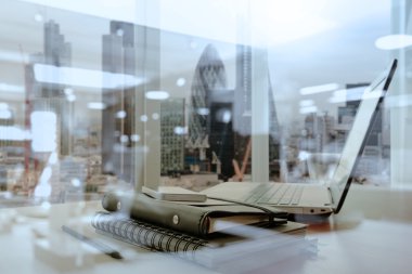 Bilgisayarı ve ahşap masasında akıllı telefonu olan bir ofis.