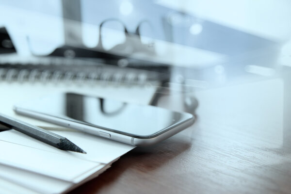 business documents on office table with smart phone and digital 