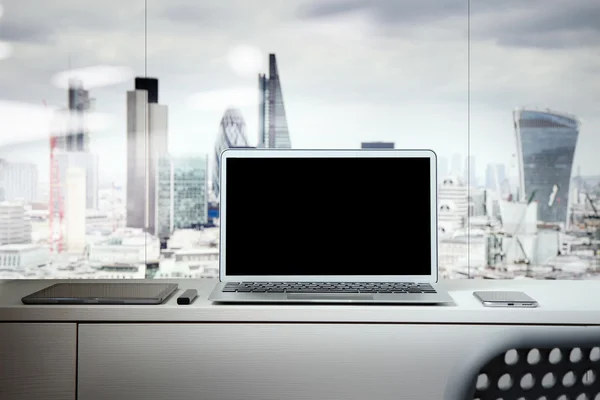 Laptop com tela em branco na mesa branca com fundo borrado a — Fotografia de Stock