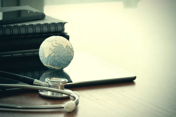 Stéthoscope et globe de texture avec tablette numérique comme filet médical — Photo