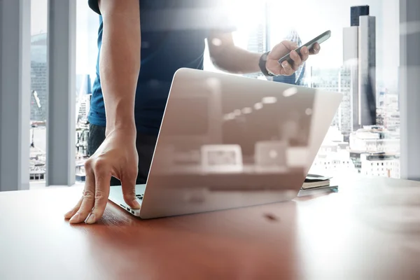 Designer mão de trabalho e telefone inteligente e laptop na mesa de madeira — Fotografia de Stock