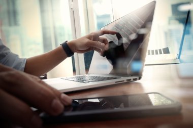 Tasarımcı el çalışma ve akıllı telefon ve ahşap masa laptop 