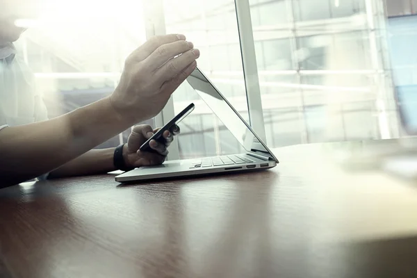 Ontwerper hand werken en smartphone en laptop op houten bureau — Stockfoto