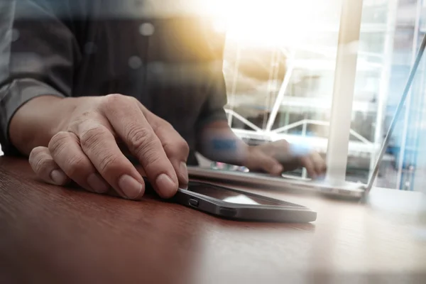 Designer mão de trabalho e telefone inteligente e laptop na mesa de madeira — Fotografia de Stock