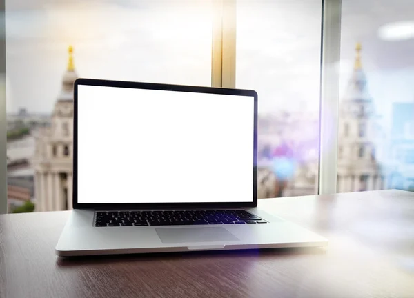 Ordenador portátil con pantalla en blanco en escritorio blanco con fondo borroso a —  Fotos de Stock