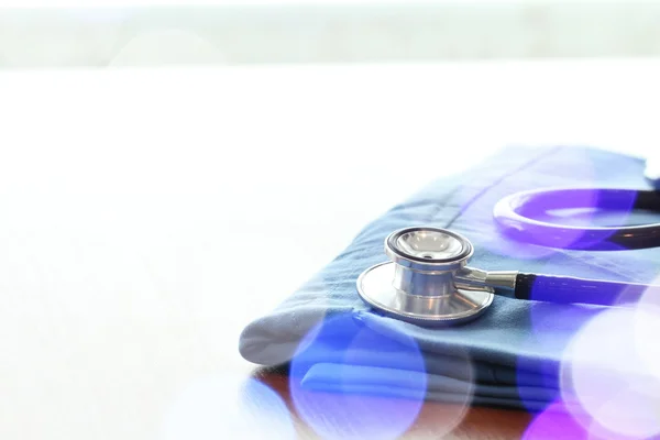 听诊器与蓝色医生外套上的木桌上浅 D — 图库照片