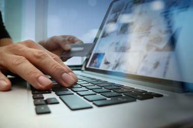 close up of hands using laptop and holding credit card as Online