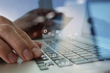 close up of hands using laptop and holding credit card with soci