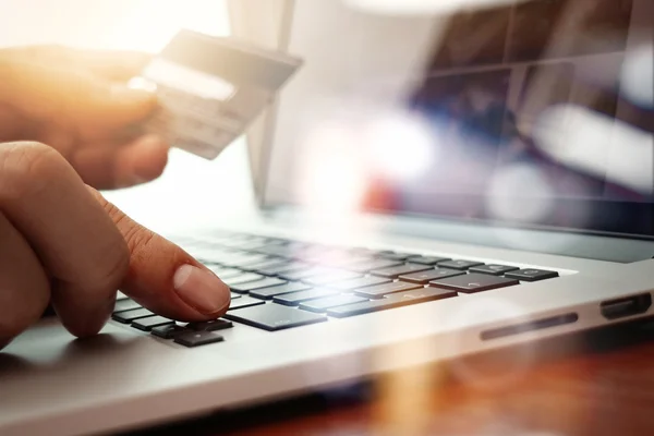 Fechar as mãos usando laptop e segurando cartão de crédito como Onlin — Fotografia de Stock