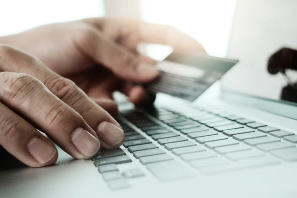Fechar as mãos usando laptop e segurando cartão de crédito como Onlin — Fotografia de Stock