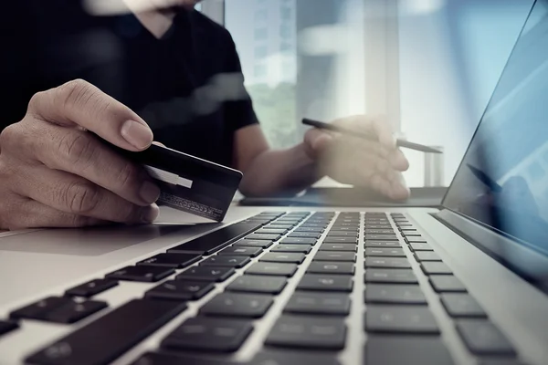 Fechar as mãos usando laptop e segurando cartão de crédito como Online — Fotografia de Stock