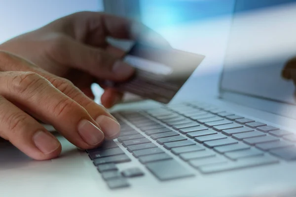 Fechar as mãos usando laptop e segurando cartão de crédito como Online — Fotografia de Stock