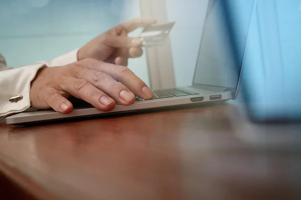 Close up of hands using laptop and holding credit card as Online — Stok fotoğraf